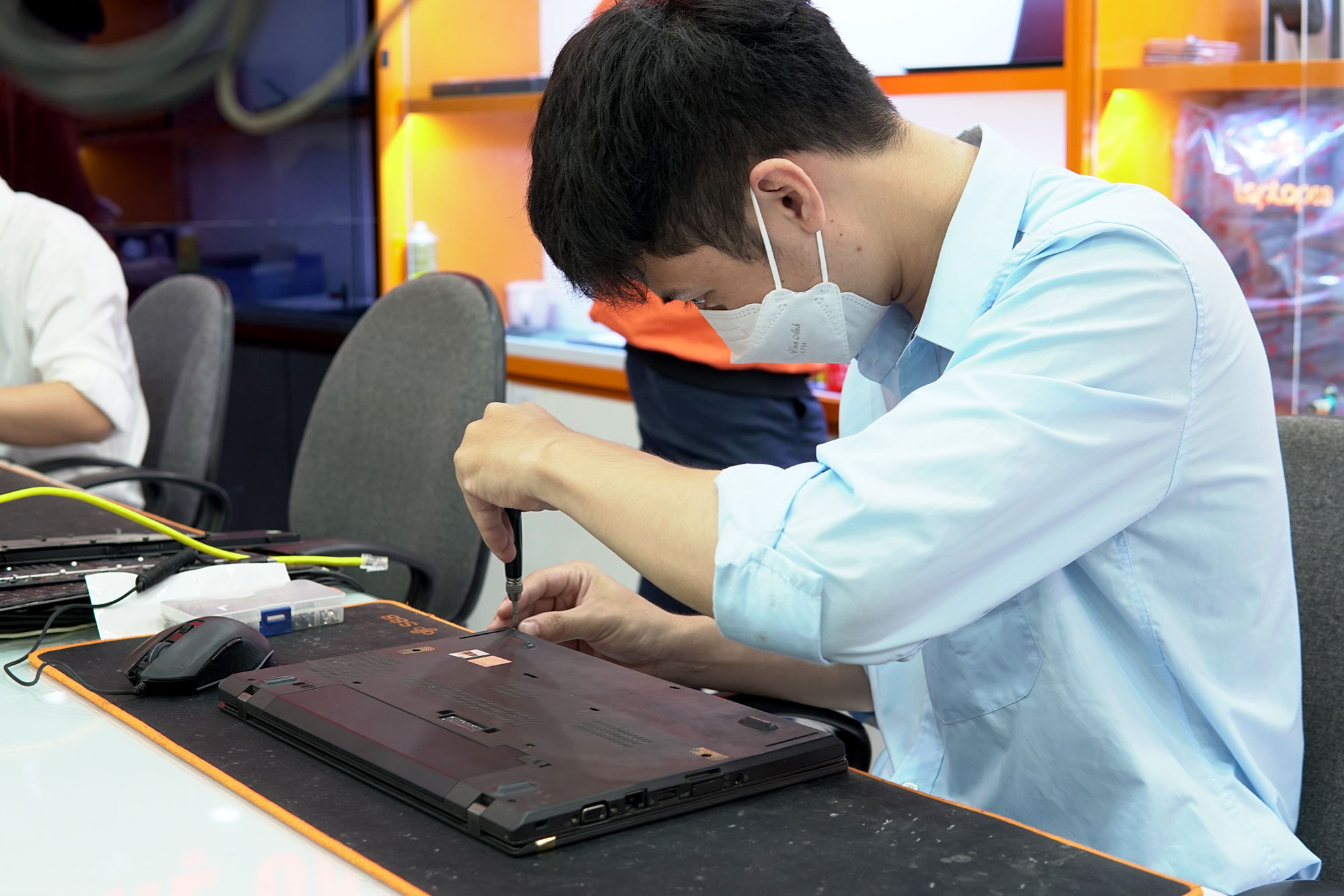 cửa hàng sửa bàn lể laptop thiên long kỹ thuật đang thay, khách hàng ngồi xem trực tiếp