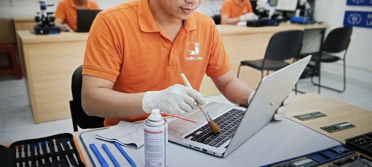 Kỹ thuật viên đang tra keo tản nhiệt và vệ sinh laptop chuyên sâu tại nhà khách hàng Quận 7